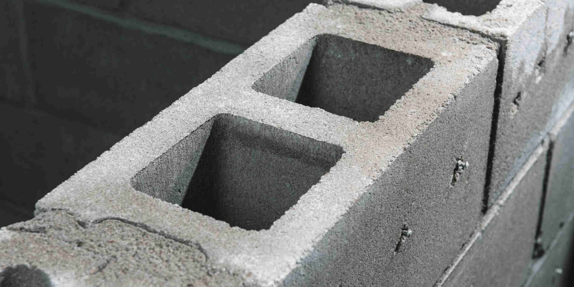 Das Bild zeigt vier Mitarbeiter, zwei Männer und zwei Frauen, die am Tisch sitzen, während eine der Frauen eine Präsentation über Hilti BIM hält. Die Präsentation wird auf dem Bildschirm angezeigt, der an einer Seite des Tisches steht.