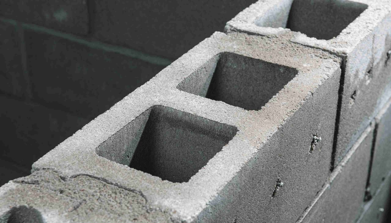 Das Bild zeigt vier Mitarbeiter, zwei Männer und zwei Frauen, die am Tisch sitzen, während eine der Frauen eine Präsentation über Hilti BIM hält. Die Präsentation wird auf dem Bildschirm angezeigt, der an einer Seite des Tisches steht.